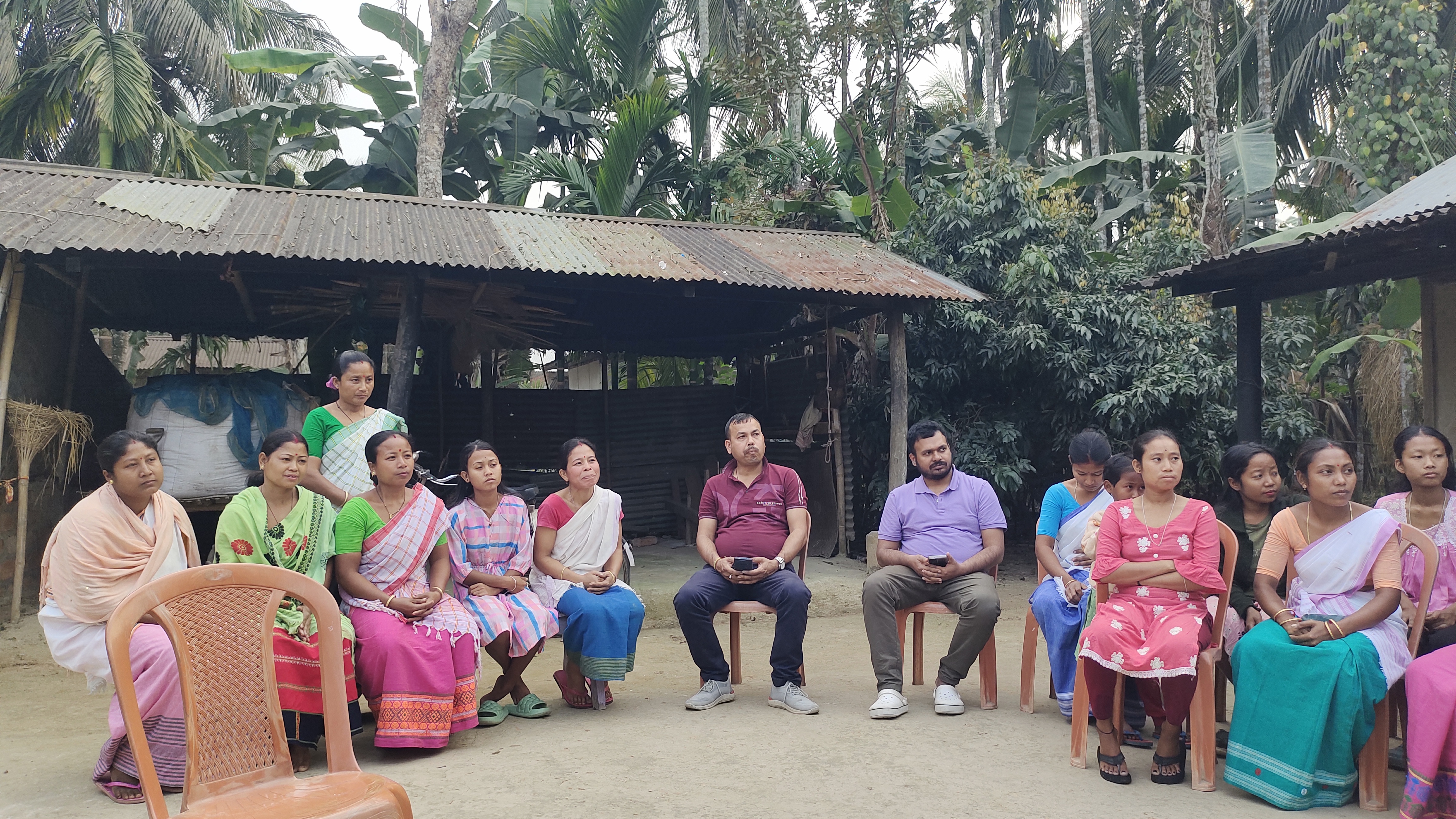 Women farmers and team members in a community meeting